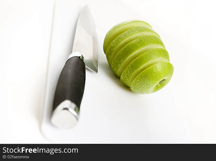 Sliced green apple in multiple peices with knife. Sliced green apple in multiple peices with knife