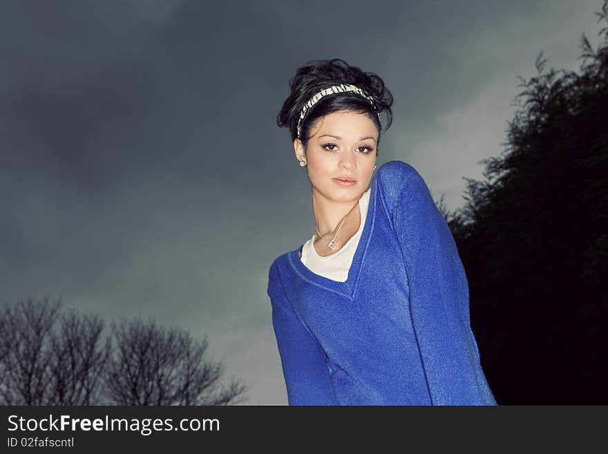 Young girl modeling outside beneath a cloudy sky. Young girl modeling outside beneath a cloudy sky