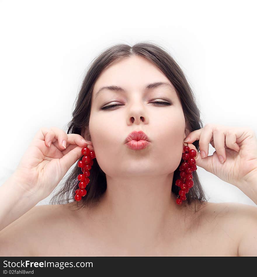 Young girl holds clusters of a red currant as ear rings