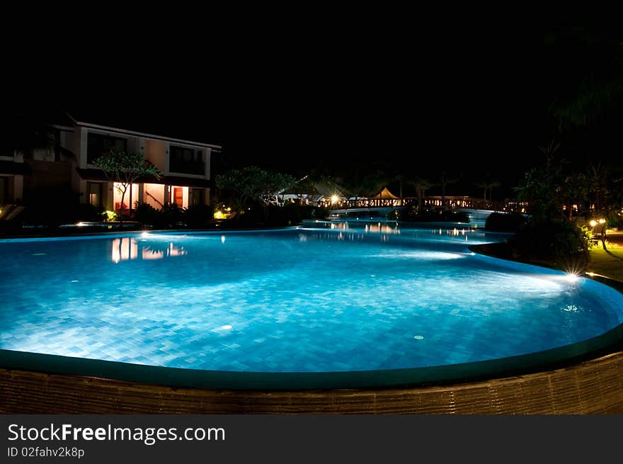 A pretty swimming pool in night at a local resort