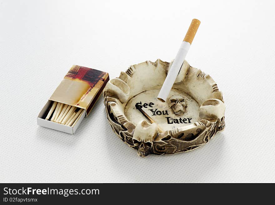 Cigarette in skull ashtray with matches