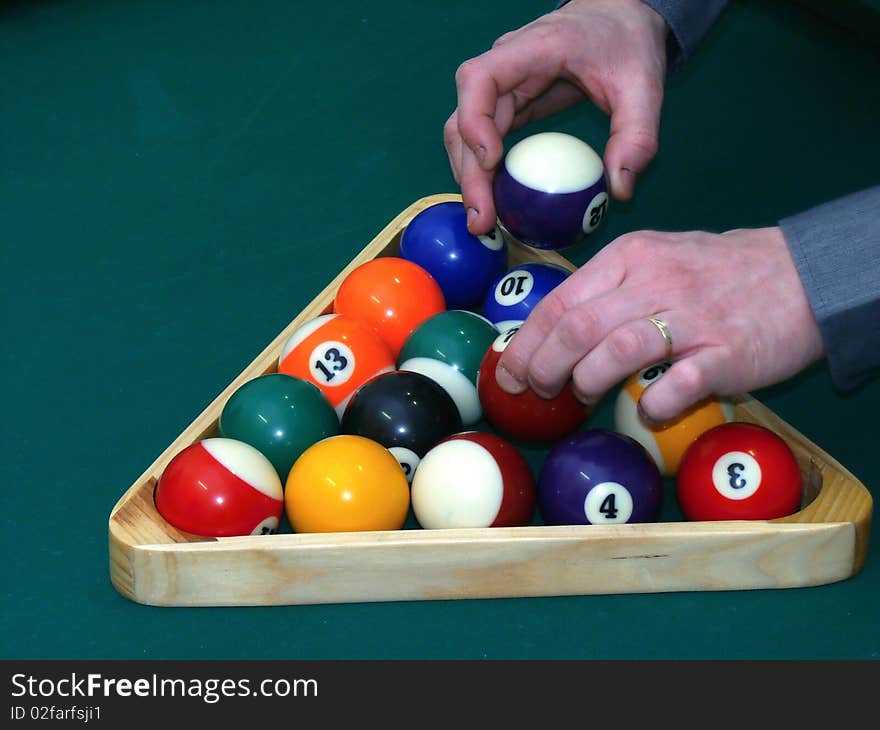 Billiard balls on green table with hands