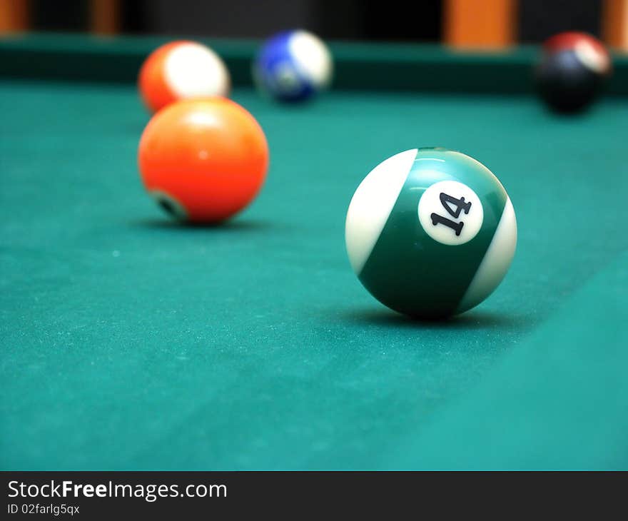 Billiard balls on green table - orange and half green