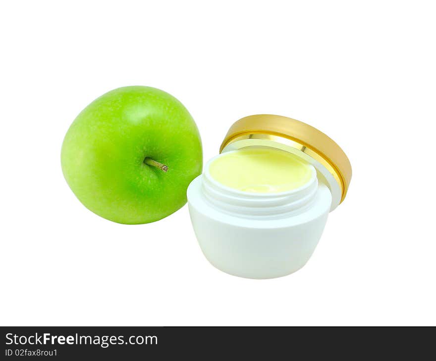 Jar of a fruit cosmetic cream and green apple on a white background close up;