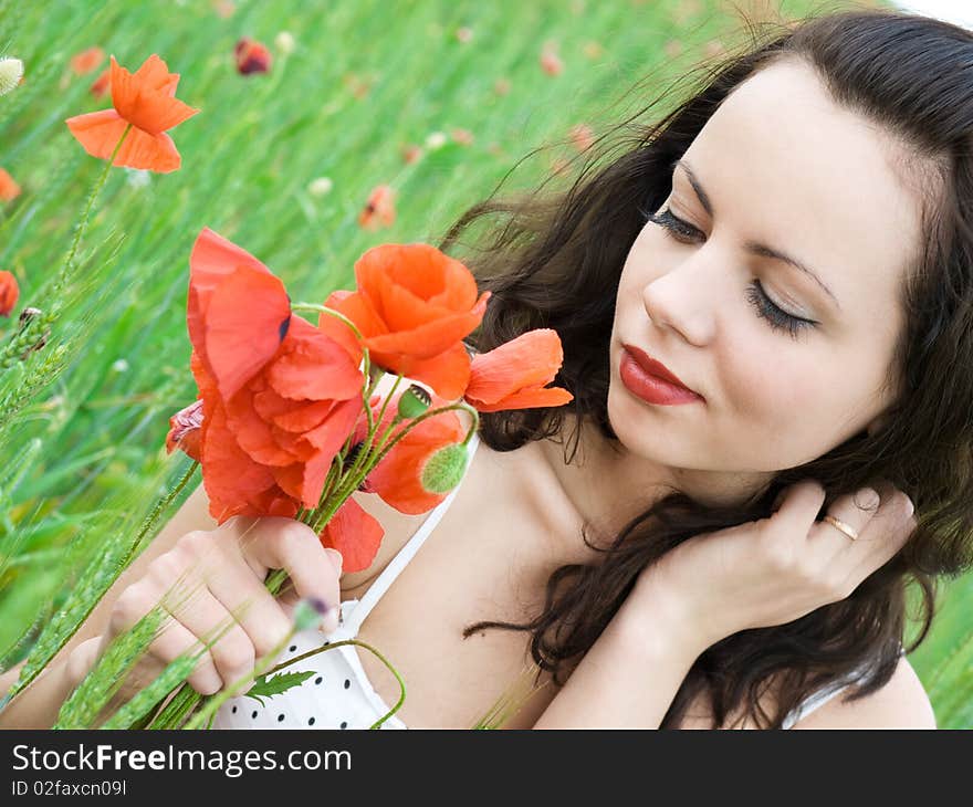 Beautiful girl with long hair posing at poppy meadow. Beautiful girl with long hair posing at poppy meadow