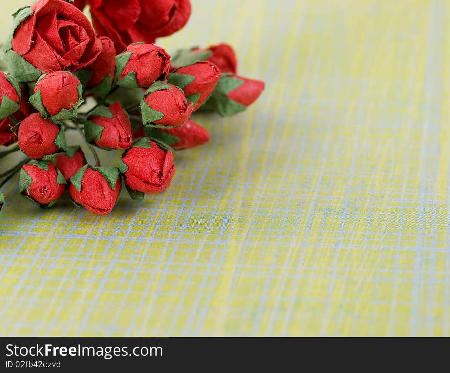 Closeup shot of red paper flowers on green background