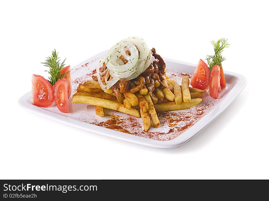 Meat with fries decorated with tomatoes and onion on white plate