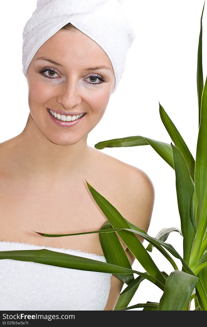 Caucasian woman in towel on head and green plant leaves. Caucasian woman in towel on head and green plant leaves