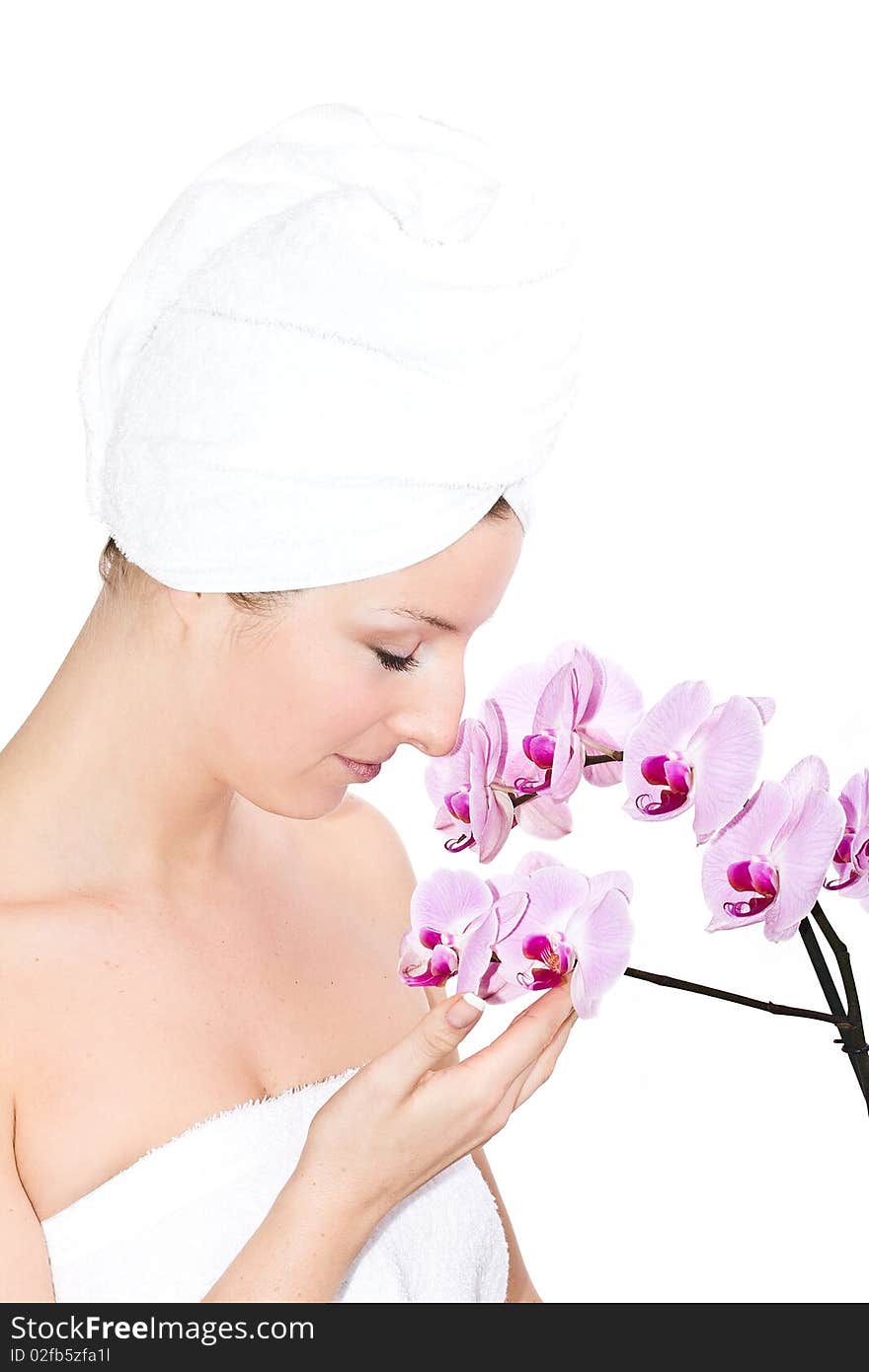 Caucasian woman with towel on head and violet orchids flowers. Caucasian woman with towel on head and violet orchids flowers