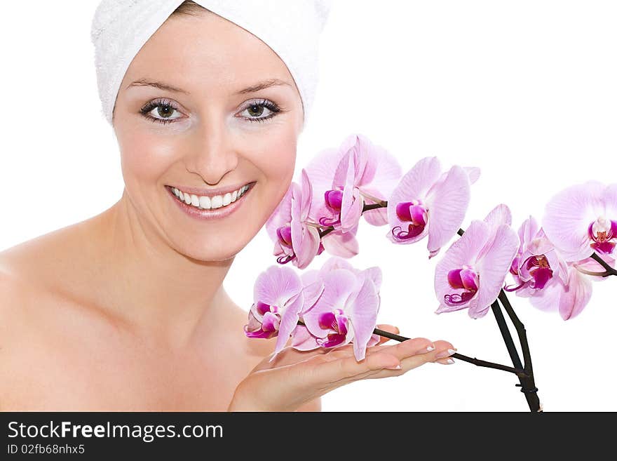 Caucasian woman on white background in towel on head with violet orchid flowers. Caucasian woman on white background in towel on head with violet orchid flowers