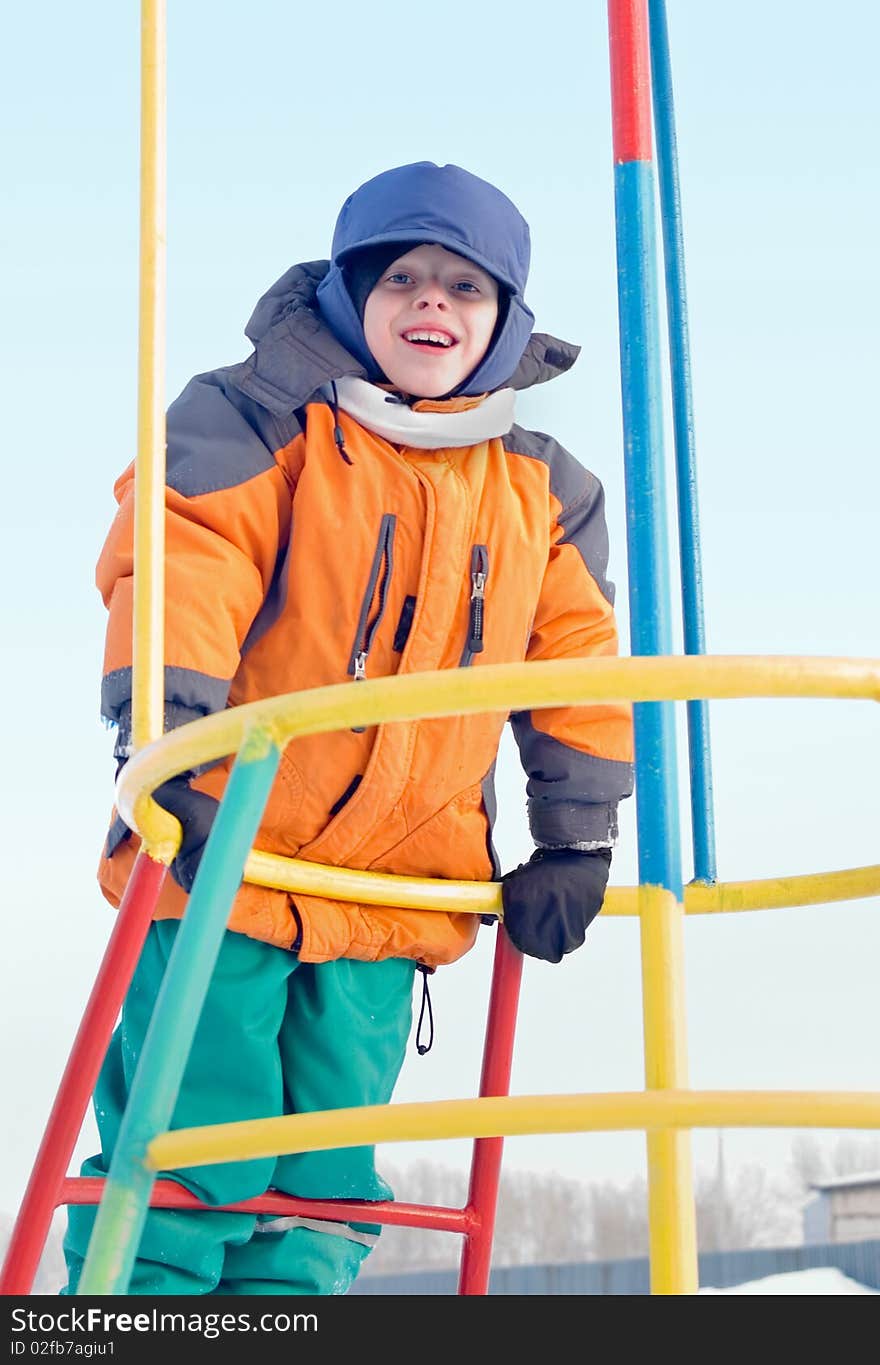 The boy plays a children's playground, cheerfully