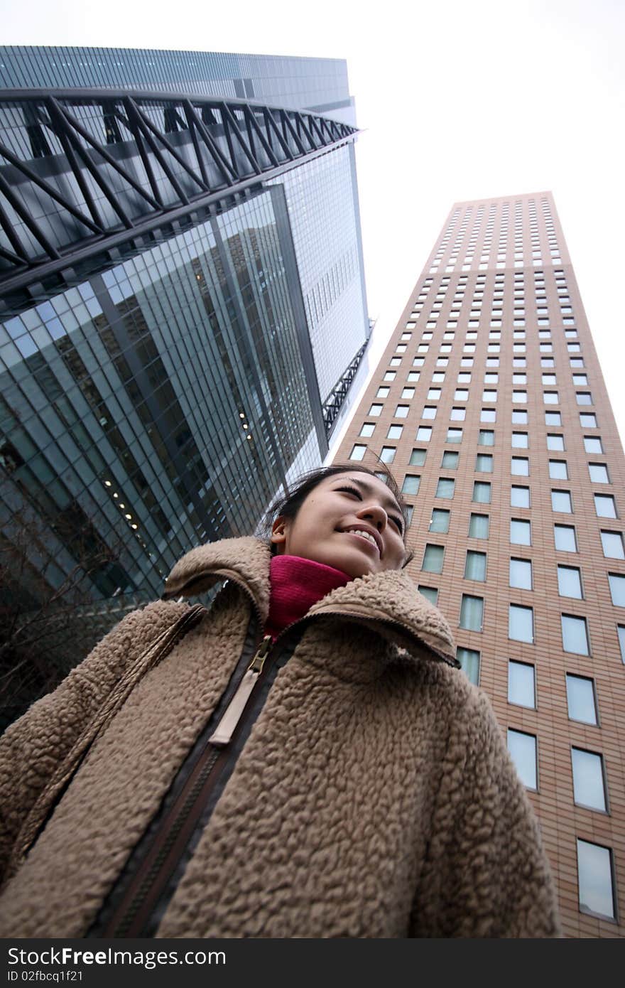 Young Japanese girl in front of buildings