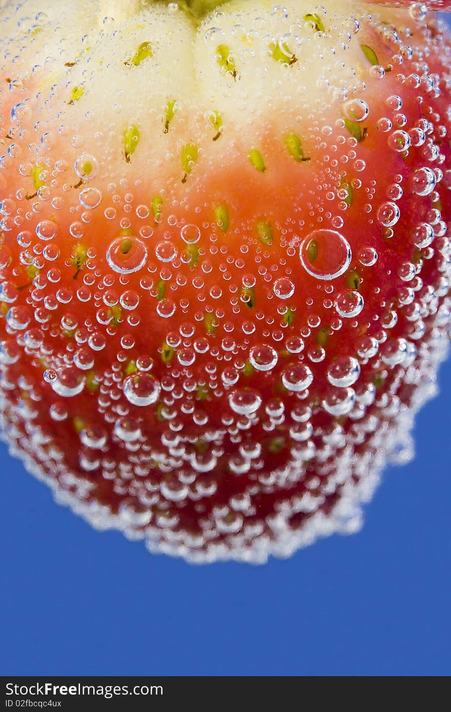 Close up on a strawberry in sparkling water.