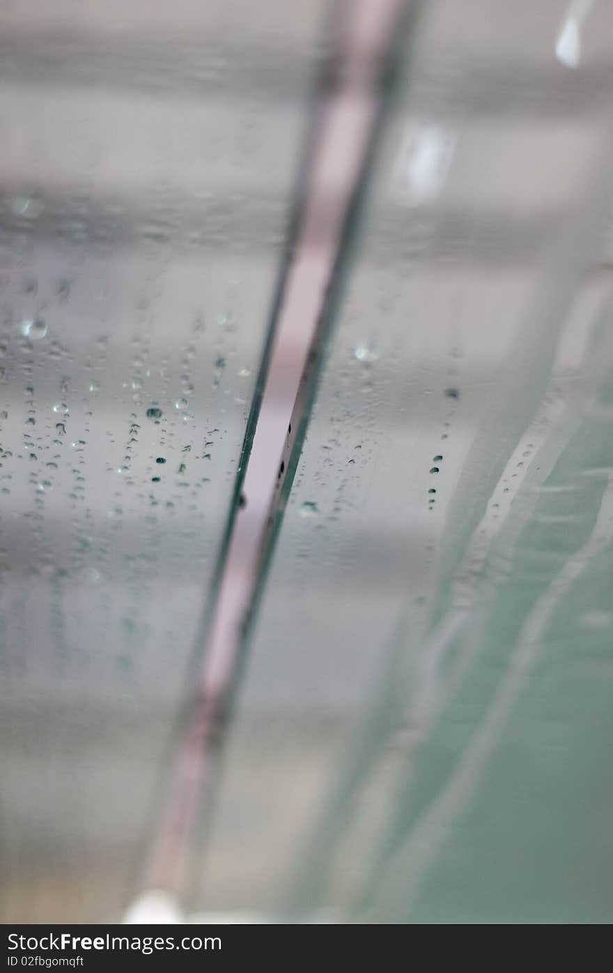 Glass with rain , focus shot .