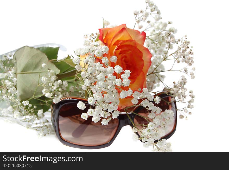 Sun glasses and bunch of flowers on a white background