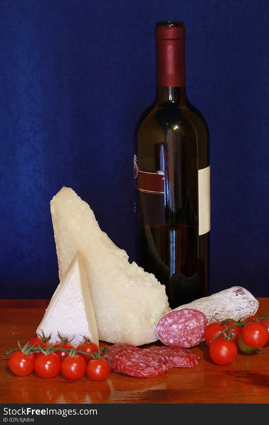 A picture of grana,salami,tomatoes and wine. A picture of grana,salami,tomatoes and wine