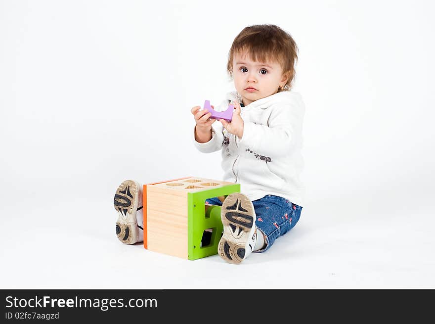 Little Girl Playing With Wooden Puzzle Cube