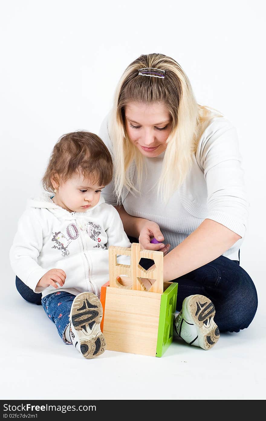 Mother and little daughter playing with puzzle cub