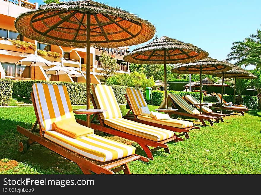 Tropical beach umbrellas and deck-chairs.