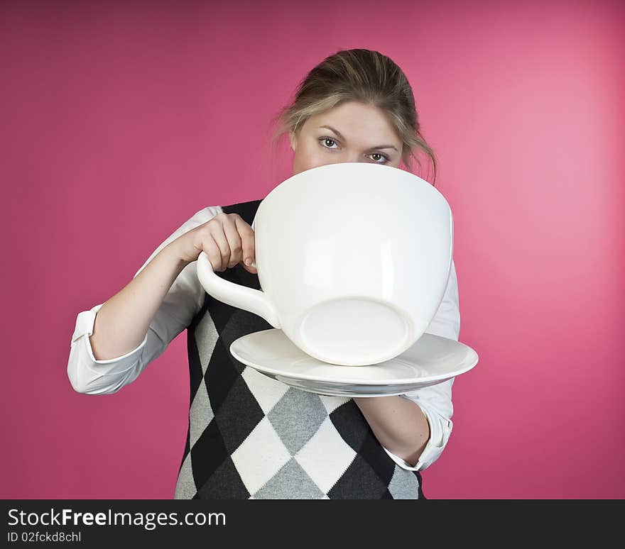 Young girl about to drink from extra large cup, studio