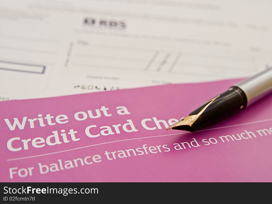 A macro image with selective focus of an invitation to write out a credit card check (or cheque ) showing an actual check and a pen with which to write it. A macro image with selective focus of an invitation to write out a credit card check (or cheque ) showing an actual check and a pen with which to write it.