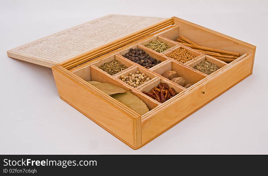 A macro image of a box containing a variety of spices isolated on a plain bright background. A macro image of a box containing a variety of spices isolated on a plain bright background.