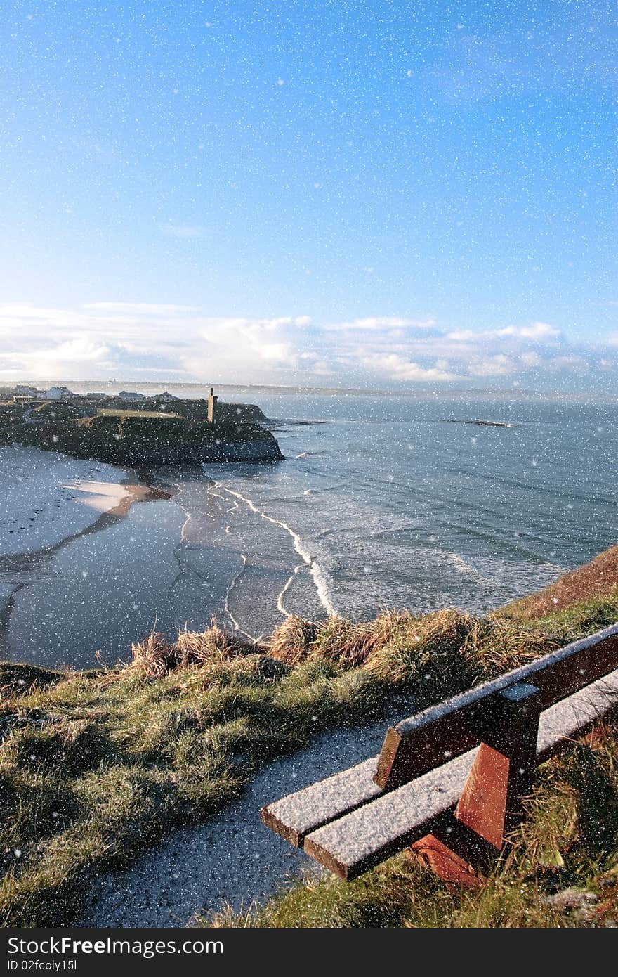 Ballybunion bench in winter snow storm with view of castle beach and cliffs. Ballybunion bench in winter snow storm with view of castle beach and cliffs