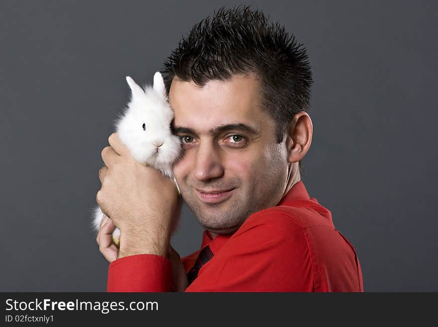 Handsome young man holding baby rabbit. Handsome young man holding baby rabbit