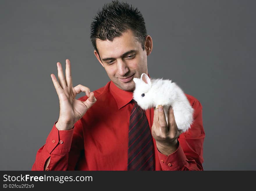 Handsome young man holding baby rabbit. Handsome young man holding baby rabbit