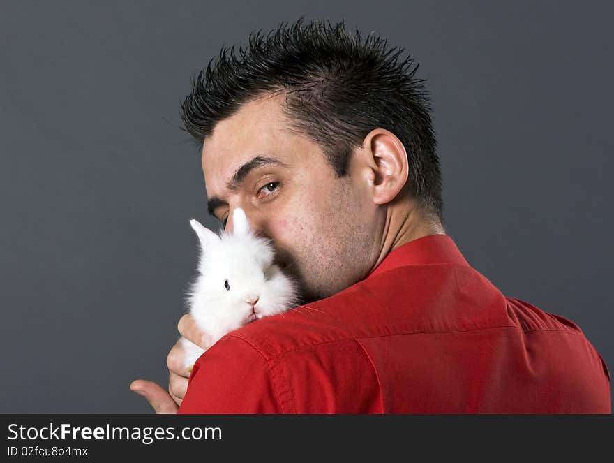 Handsome young man holding baby rabbit. Handsome young man holding baby rabbit