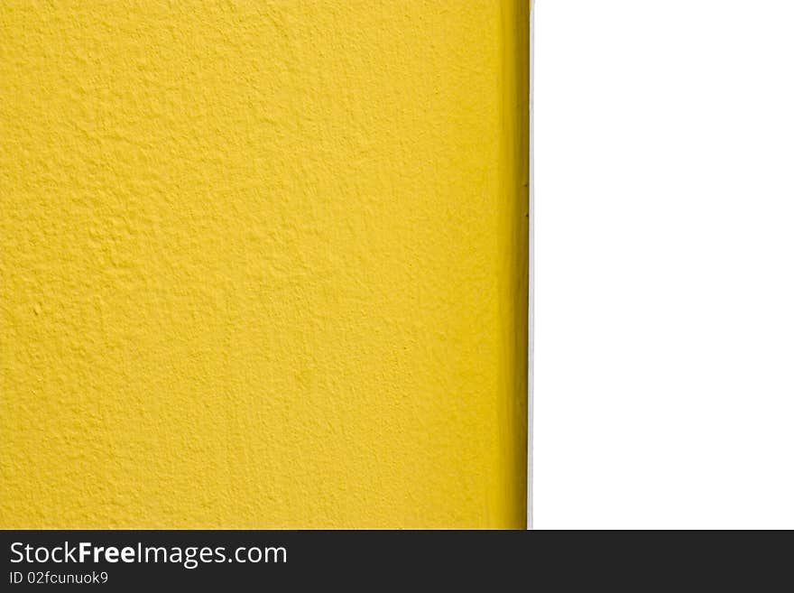 A yellow painted rough textured wall and smooth white plastic edge. A yellow painted rough textured wall and smooth white plastic edge