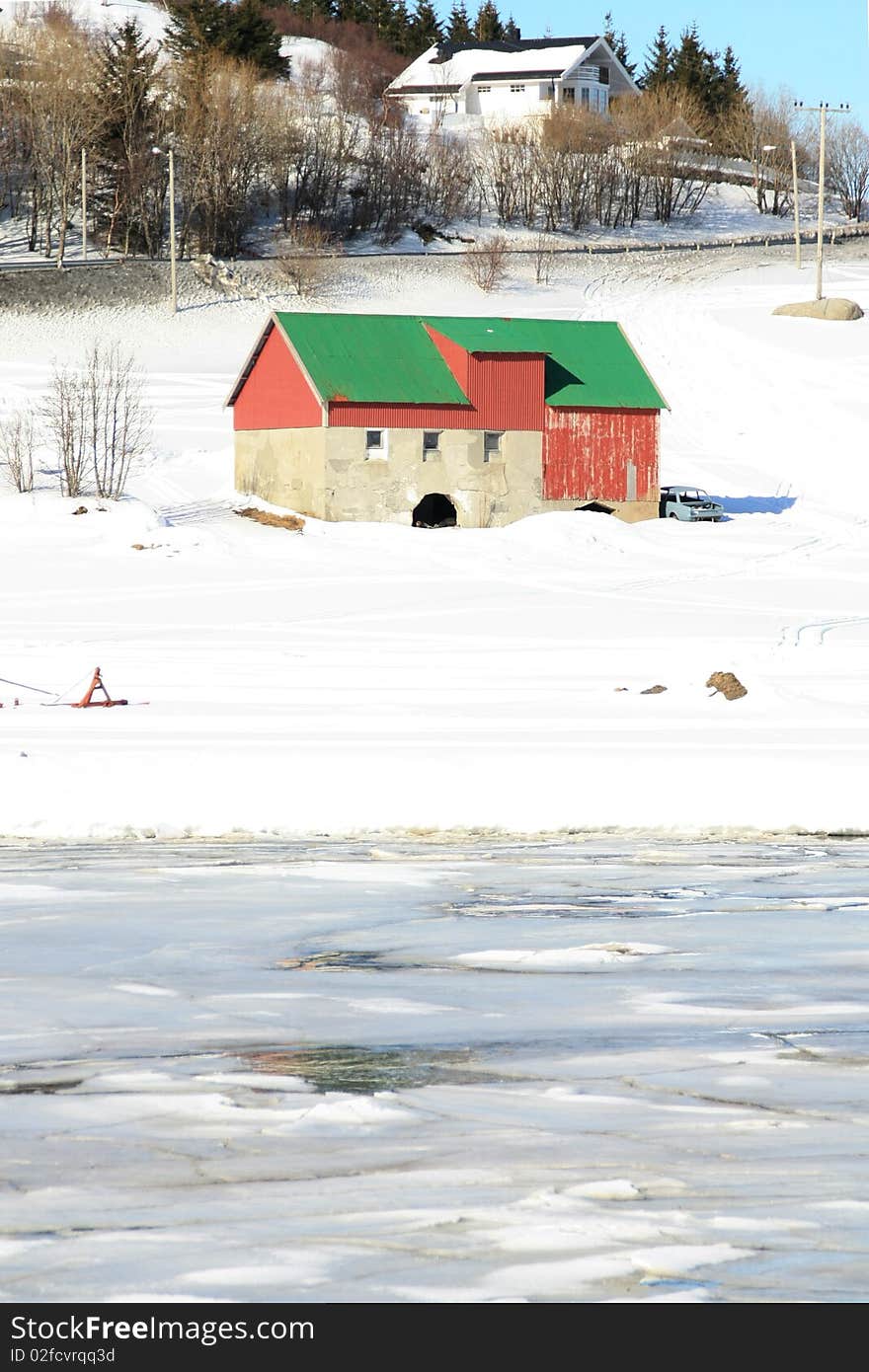 Traditional hayloft of Lofoten islands, besides the icy Busknes fjord. Traditional hayloft of Lofoten islands, besides the icy Busknes fjord