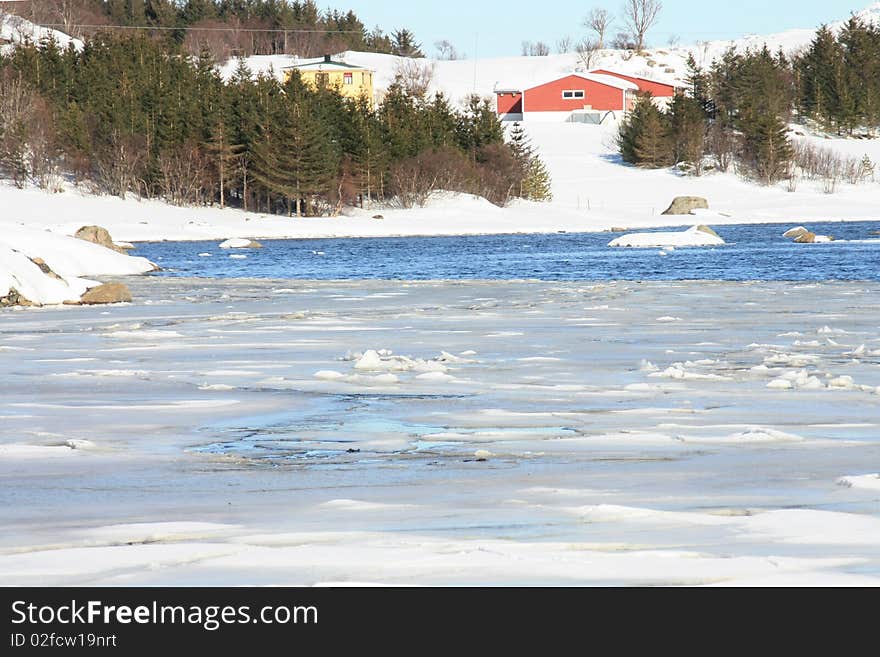 Red barn  on icy  fjordside