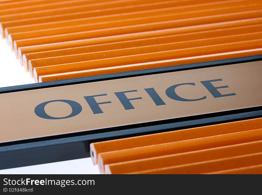 The tablet with a word office on a table among pencils for work at office. The tablet with a word office on a table among pencils for work at office.