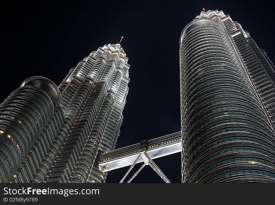 The Petronas Twin Towers by night, photographed from a low angle.