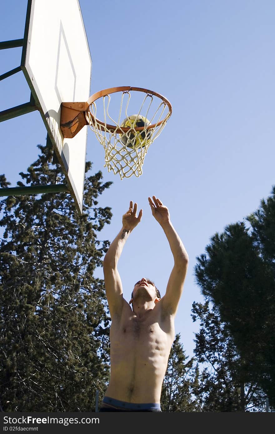 A young man throwing the ball at the basket. A young man throwing the ball at the basket