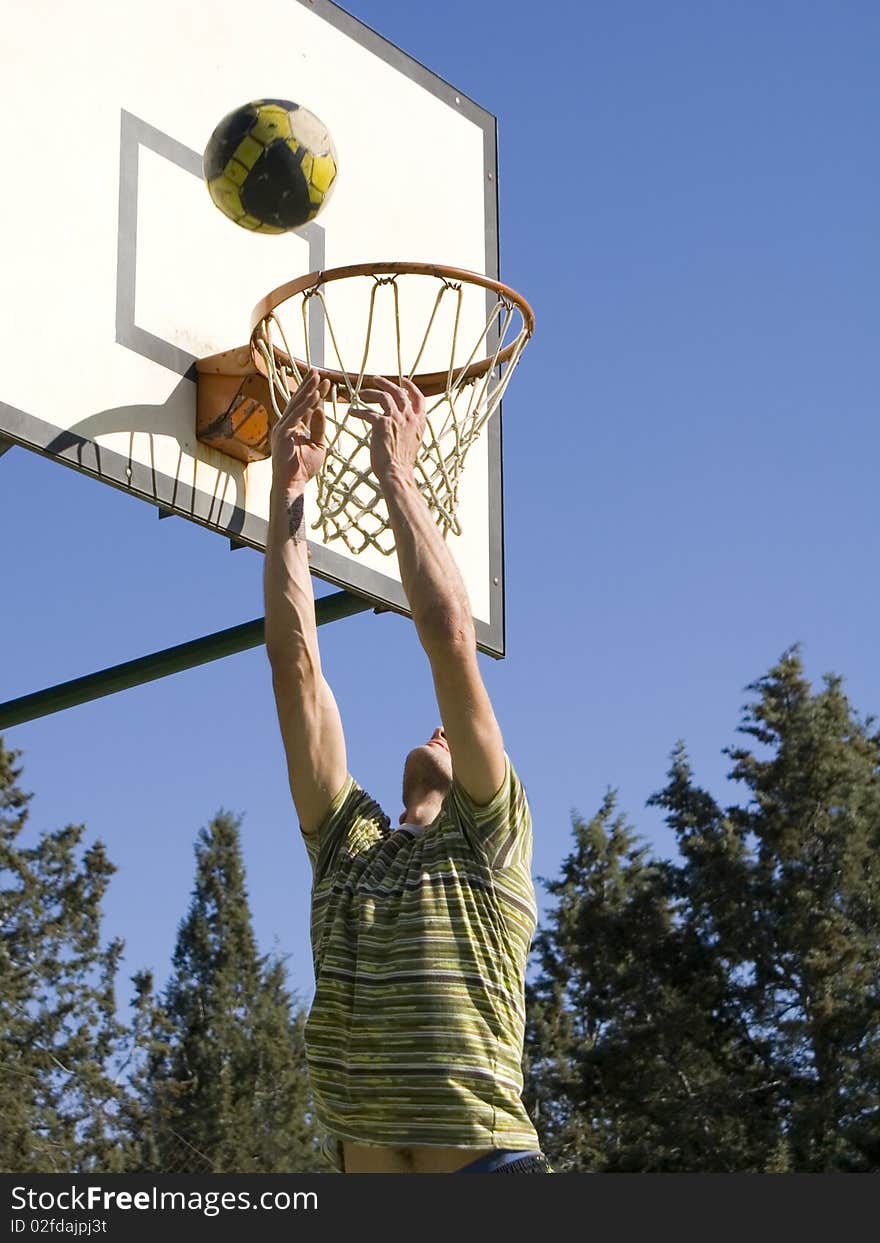 A young man throwing the ball at the basket. A young man throwing the ball at the basket