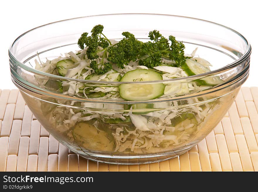 Salad in a glass bowl from cabbage of a cucumber and the fennel, isolated on a white background