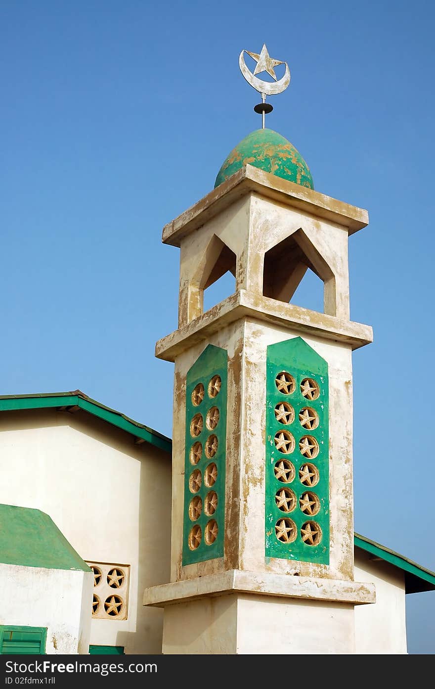 Old mosque with minaret and crescent moon and star finial