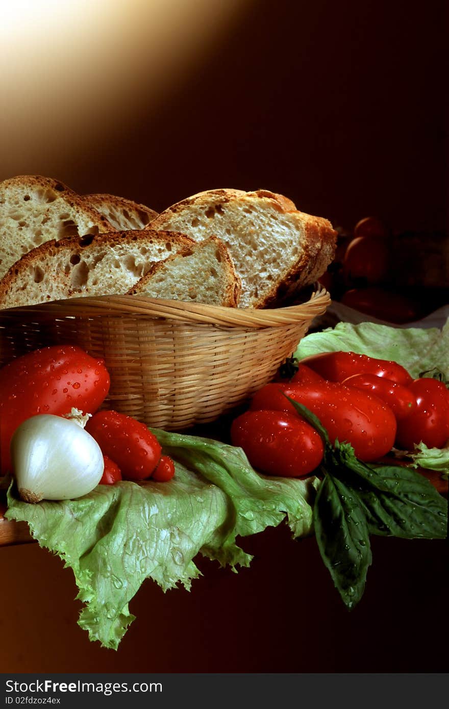 Slices of bread in basket with tomatoes, in country style