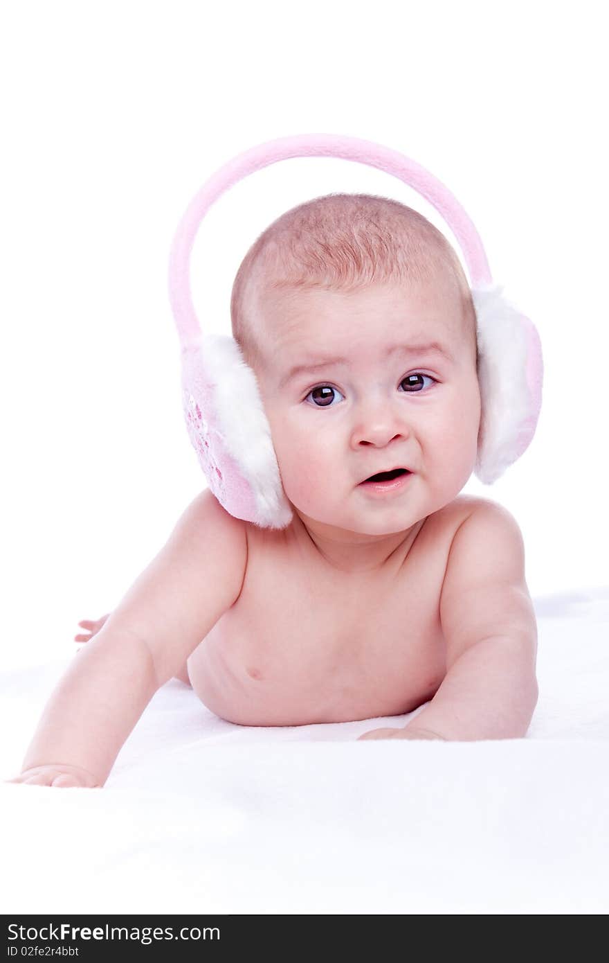 Happy baby with pink fur headphones on white background