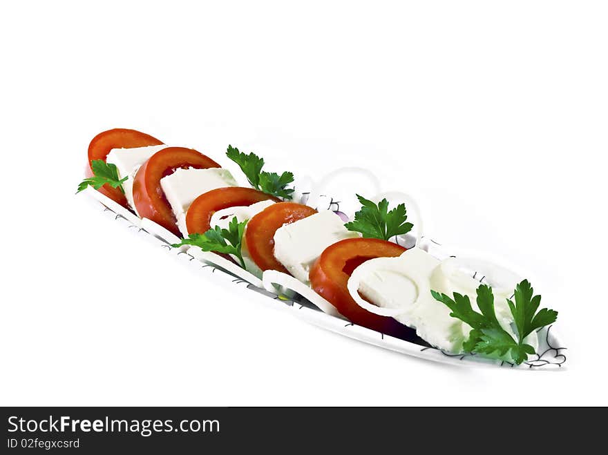 Sliced cheese and tomatoes, decorated with greenery, isolated. Sliced cheese and tomatoes, decorated with greenery, isolated