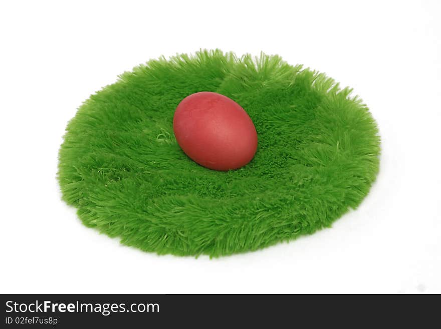 Red Easter egg on a green grass