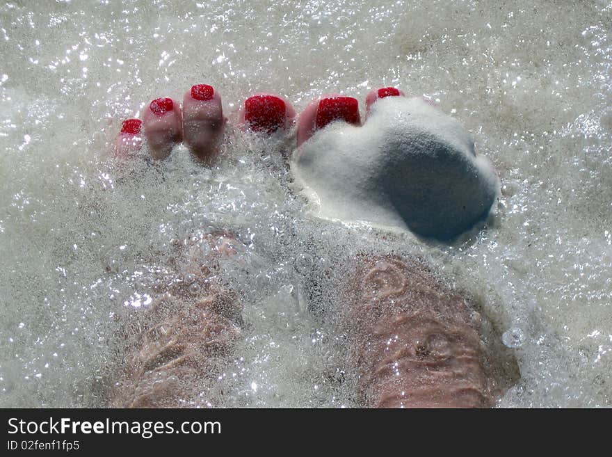 Picture of a woman's feet on the beach, deep in the sand and water. Picture of a woman's feet on the beach, deep in the sand and water