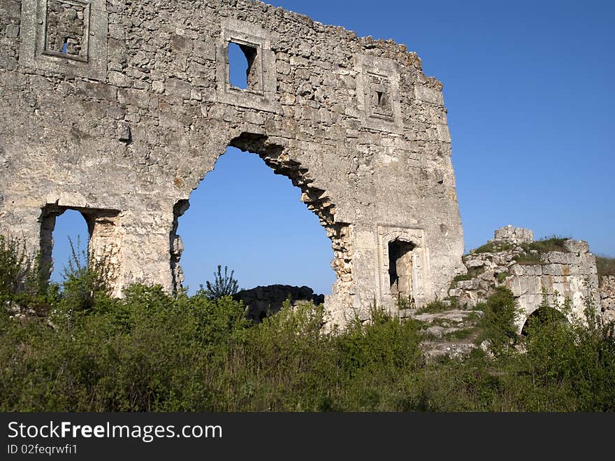 Wall of tumbledown monastery on a background dark blue sky. Wall of tumbledown monastery on a background dark blue sky