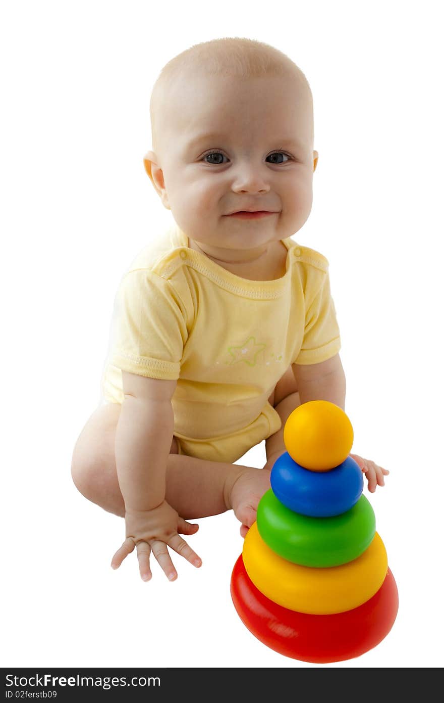 The happy baby smiles and sits next there is a toy a pyramid