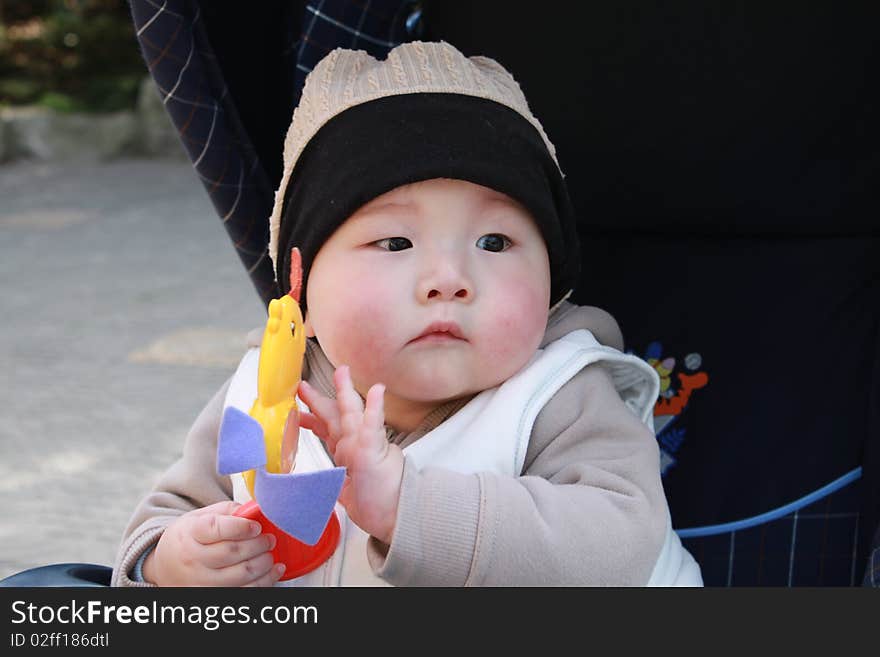 Lovely Chinese baby playing toy in the park. Lovely Chinese baby playing toy in the park