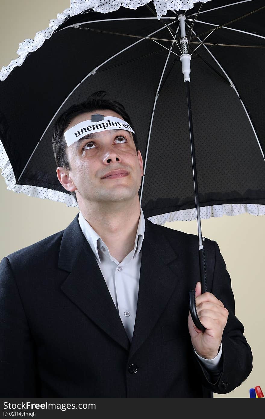 Unemployed man staying under umbrella