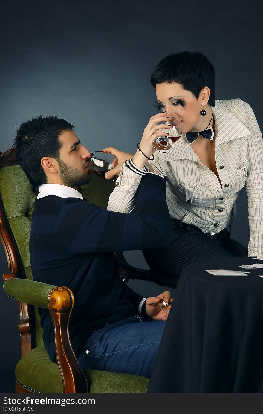 There is cool couple. He smokes cigar and holds cards. There is cool couple. He smokes cigar and holds cards.