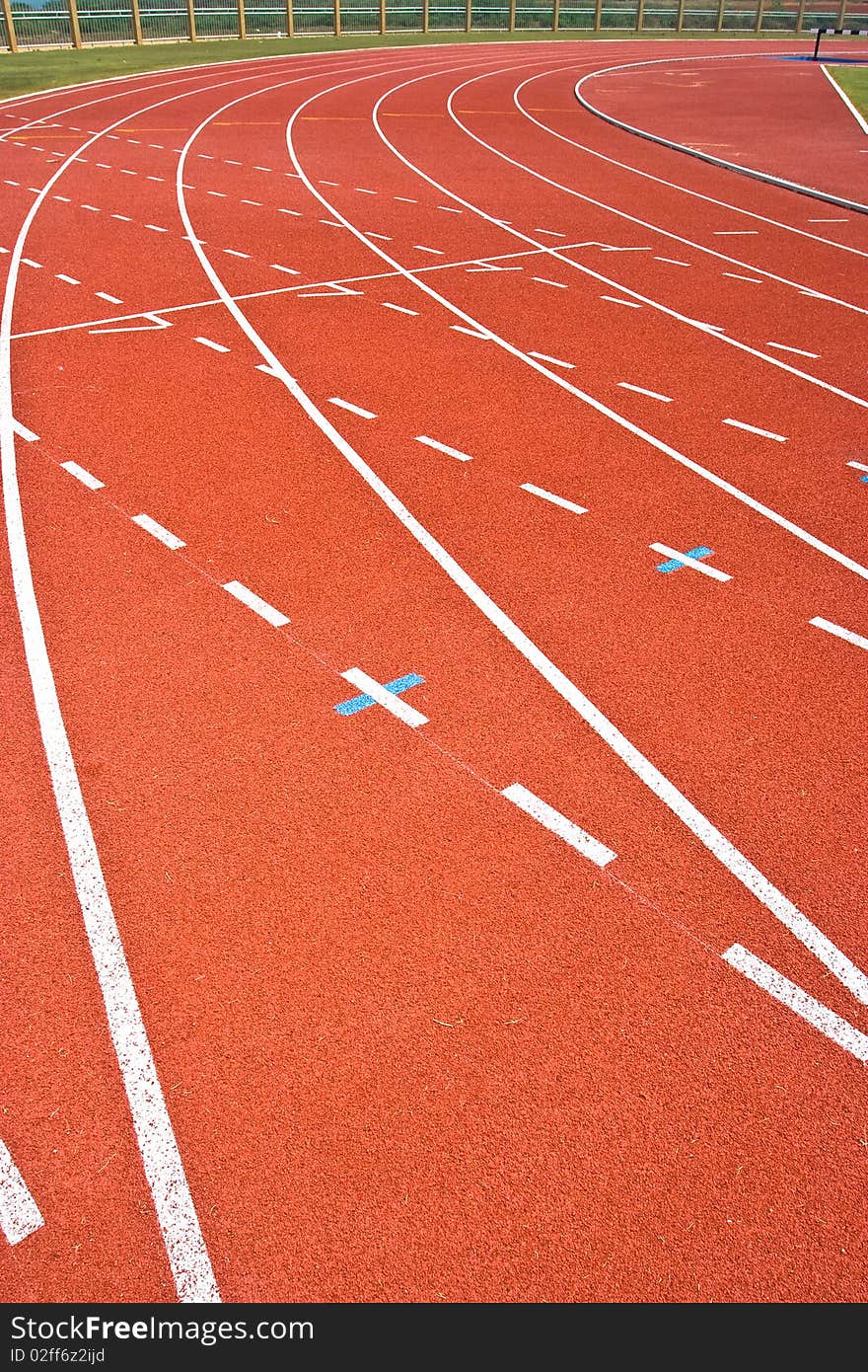 A university running track, around an grass football field.